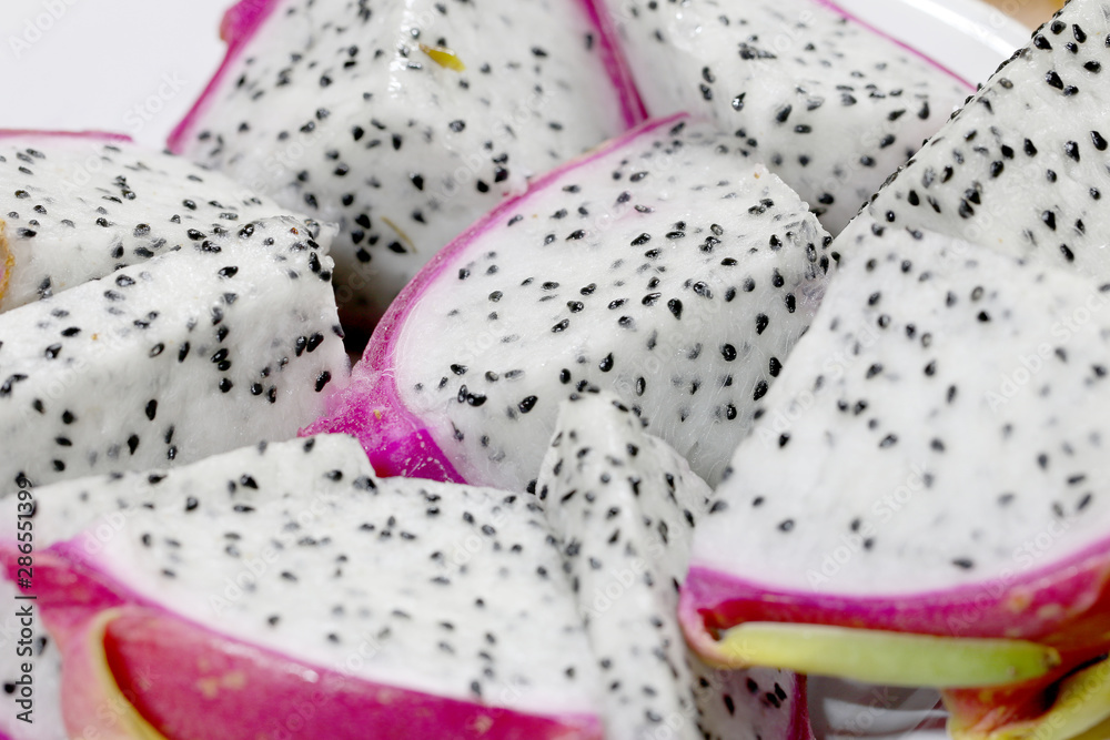 Healthy dragon fruit or pitaya pieces background, close up of beautiful fresh sliced dragon fruit with texture in the market in thailand. Pitaya is the plant in Cactaceae family or Cactus. Healthy dragon fruit or pitaya pieces background, close up of beautiful fresh sliced dragon fruit with texture in the market in thailand. Pitaya is the plant in Cactaceae family or Cactus.