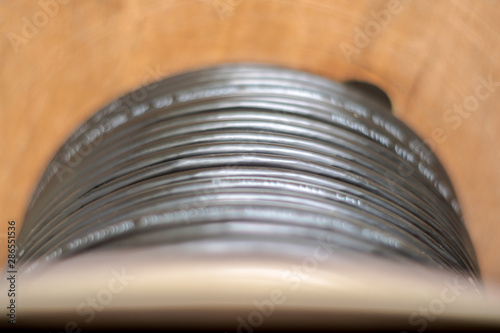 Wooden Coils of powerful black telecommunications wire. Many turns of the main electrical cable is closeup. Selective focus. Roll of outdoor fiber optic signal shielded cables.