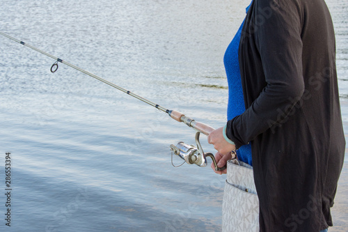 Woman fishing on a lake at spinning