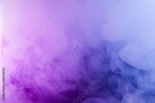 Thick smoke in the neon light. Pink and blue light  texture  background. Out of focus. Abstract dark background.