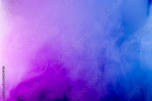 Thick smoke in the neon light. Pink and blue light, texture, background. Out of focus. Abstract dark background.