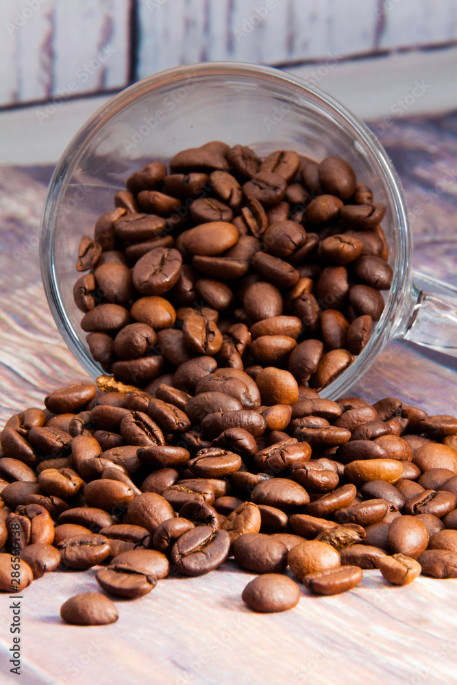 Fototapeta premium coffee beans coming out of a glass cup