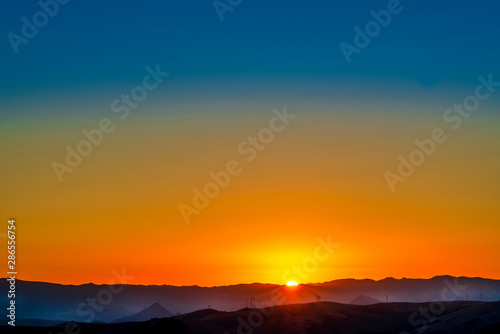 Orange Sunrise over Silhouetted Mountains © Mark