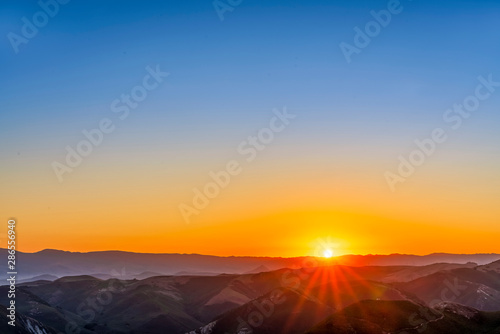 Sunrise over Silhouetted Mountains