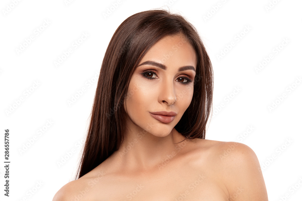 Close up portrait of a brunette nude model girl with professional evening make-up and plump lips, posing isolated on white background. Close up portrait of a brunette nude model girl with professional evening make-up and plump lips, posing isolated on white background.