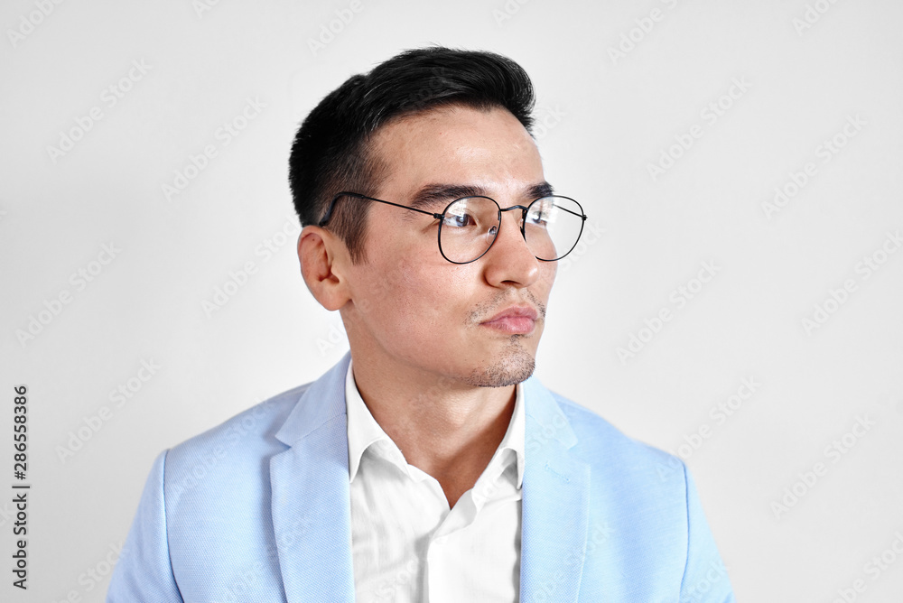 Portrait of smart thinking Kazakh man in glasses dressed in business suit in the office on white background. Asian handsome businessman