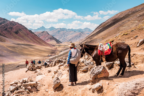 Obraz na płótnie Peruvian Cowboy with horse stands lonely in the Peruvian countryside, in the background mountains of Peru, snow covered Andes near Cusco w salonie