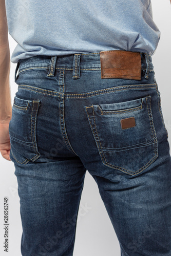 man in jeans, denim pants closeup on white background, blue jeans