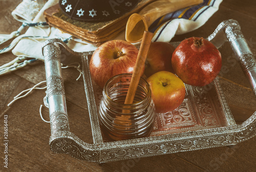 Jewish holiday honey and apples with pomegranate torah book, kippah a yamolka talit photo