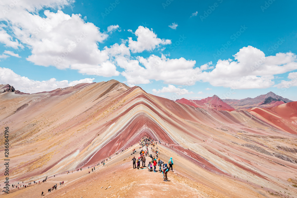 Vinicunca Rainbow Mountain, tourists standing on top of the mountain and admiring the view, Cusco, Peru