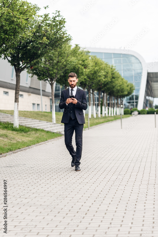 Businessman in an expensive suit and shoes goes on the square, finances and startups Businessman in an expensive suit and shoes goes on the square, finances and startups