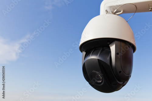 PTZ surveillance camera against the blue sky