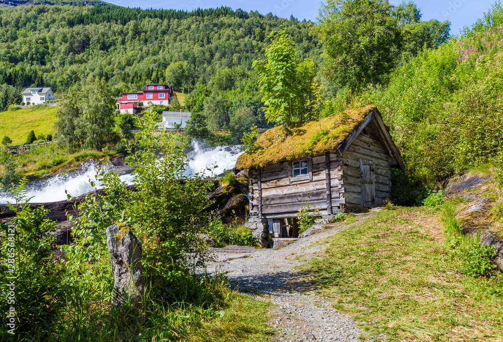 Panorama of small village Hellesylt with Hellesyltfossen waterfall in along Geiranger fjord in More og Romsdal county in Norway