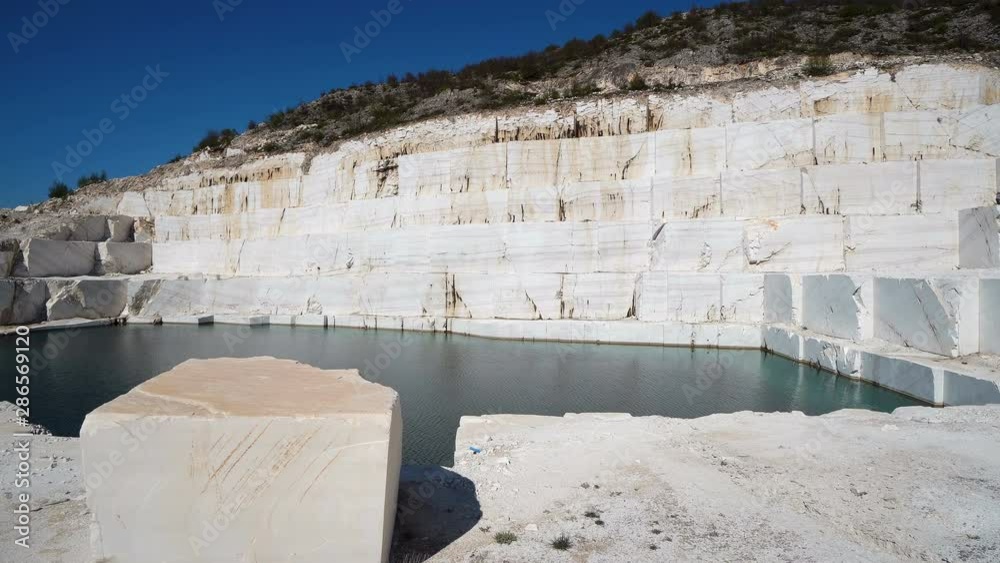Large marble blocks in open mine with formation of marble lake pamukkale in Macedonia Large marble blocks in open mine with formation of marble lake pamukkale in Macedonia