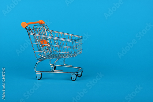 Close up retail shopping cart on blue background