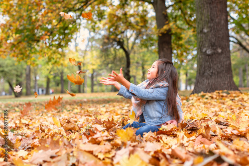 M  dchen im Herbst wirft bunte Ahornbl  tter in die Luft Natur 