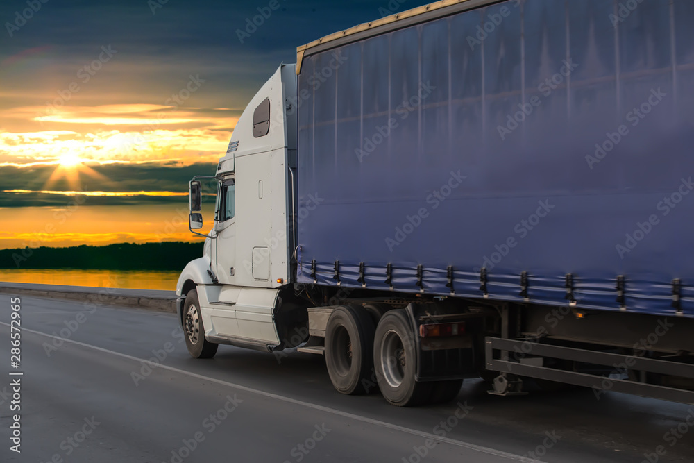 Big truck semi trailer moves on the highway