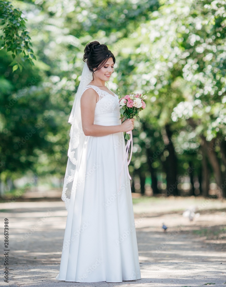 Beautiful bride with stylish make-up in white dress in spring garden Beautiful bride with stylish make-up in white dress in spring garden