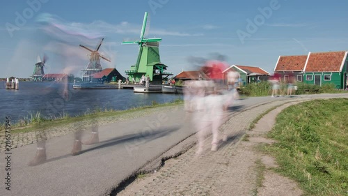 Zaandijk, Netherlands - AUGUST 25, 2019: Smooth motion blur time lapse of people walking a dike and taking pictures photo