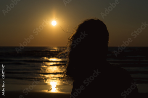 Woman at the Evening Beach at Sunset Time.