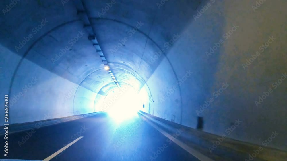 Driving pov on highway in tunnel and exit to light, concept of heaven