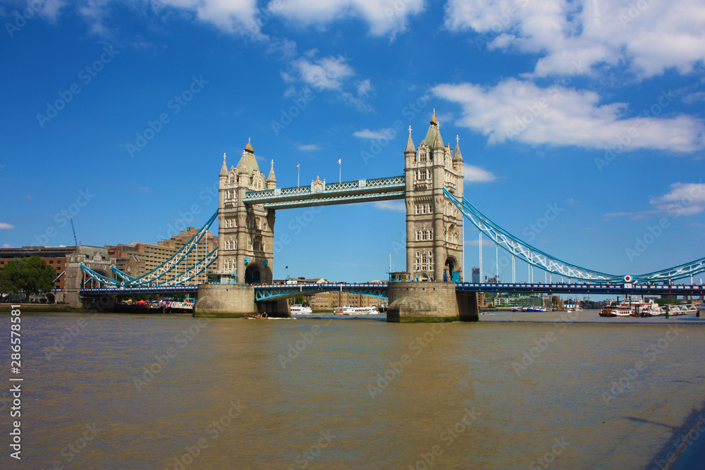 The famous London Bridge on a blue sky summer day. The tranquil water of the Thames river