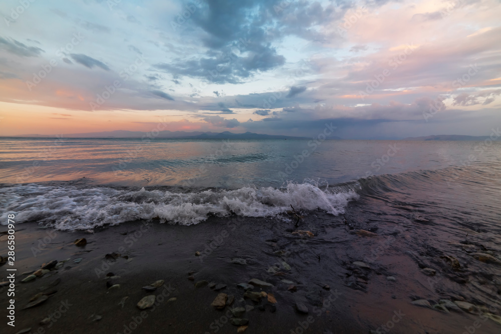 Fototapeta premium Beautiful sunrise on the lake. Fantastic sunrise colorful clouds on on the Sevan like Armenia.