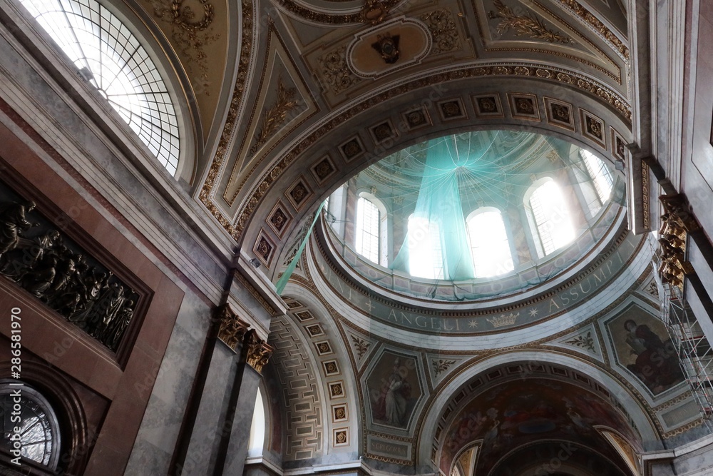 Upward view on round dome and roof of Primatial Basilica of the Blessed Virgin Mary Assumed Into Heaven and St Adalbert in Esztergom. Green protective network used during restoration visible. Upward view on round dome and roof of Primatial Basilica of the Blessed Virgin Mary Assumed Into Heaven and St Adalbert in Esztergom. Green protective network used during restoration visible.