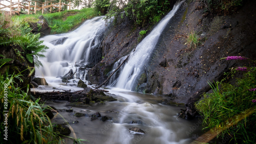 Obraz premium A small waterfall going down the stream