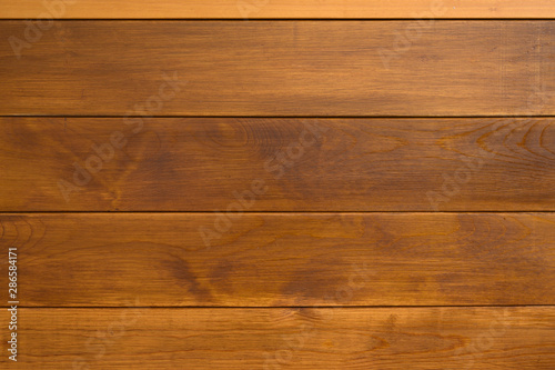 The unique texture of wooden wall made of planks colored with natural brown paint, tiled background