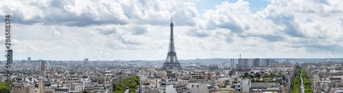 Large panoramic cityscape of Paris  France  with the Eiffel Tower centred in the image under a dramatic cloudy sky.