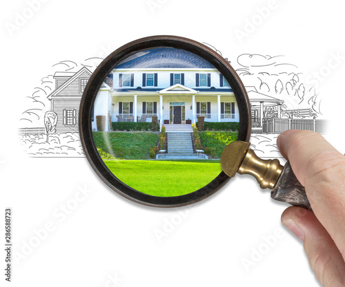 Hand Holding Magnifying Glass Revealing Finished House Build Over Drawing photo