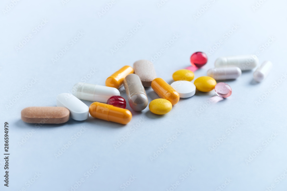 Vitamins and supplements on bright paper background. Concept for a healthy dietary supplementation. Close up. Copy space. Vitamins and supplements on bright paper background. Concept for a healthy dietary supplementation. Close up. Copy space.