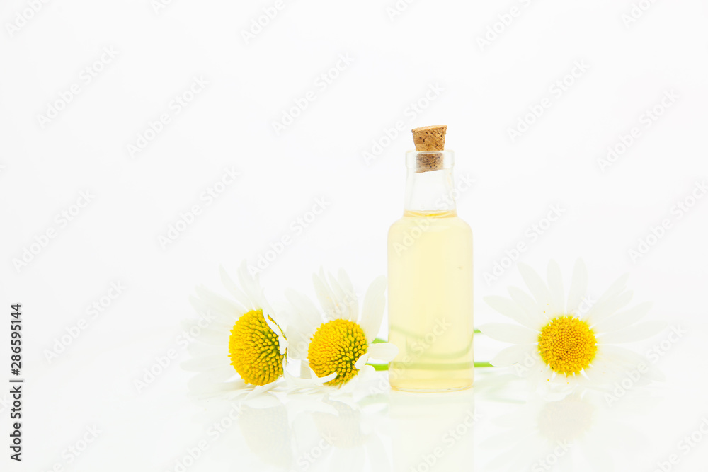 Essence of flowers on table in beautiful glass bottle Essence of flowers on table in beautiful glass bottle