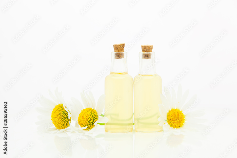 Essence of flowers on table in beautiful glass bottle Essence of flowers on table in beautiful glass bottle