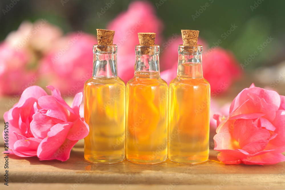 Essence of rose on table in beautiful glass bottle