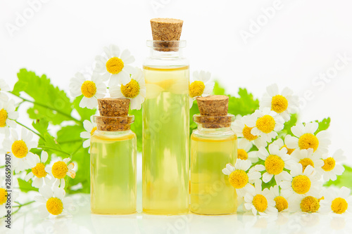 Essence of flowers on table in beautiful glass bottle