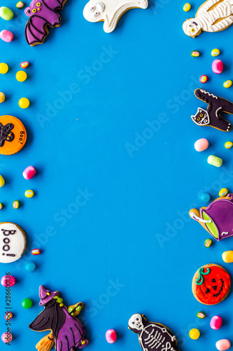 Halloween decorations frame on blue background top view copyspace