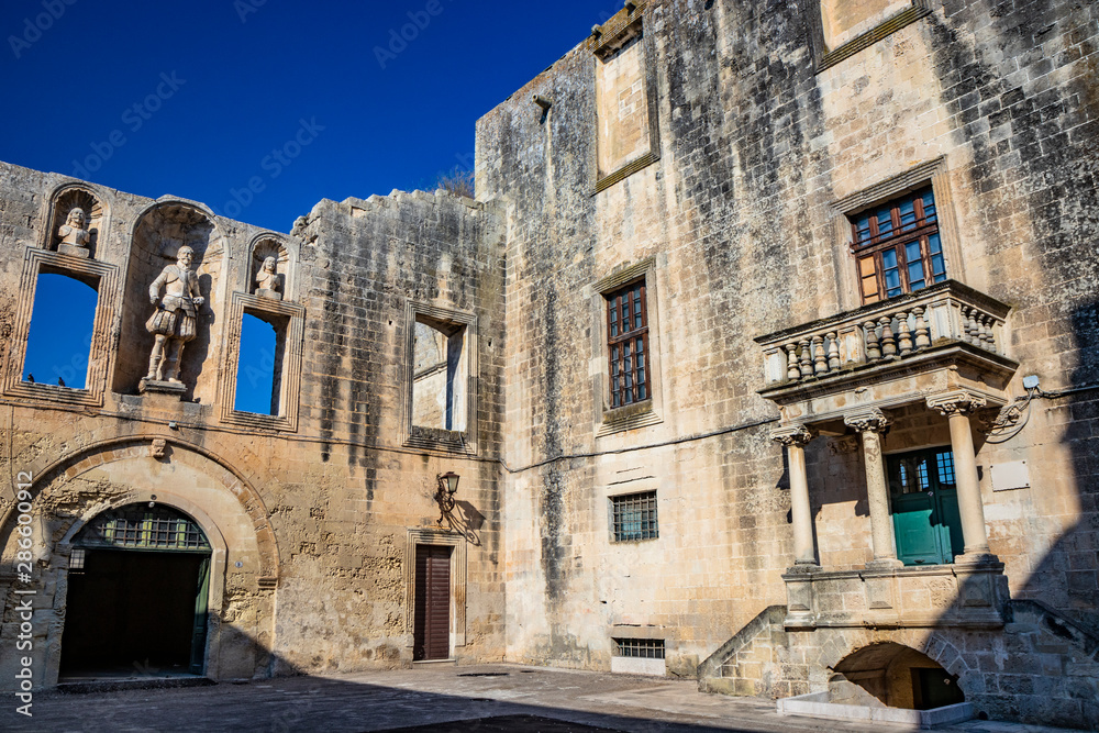 The courtyard of the castle, or ducal palace, of the Castromediano Lymburgh, in Cavallino, Lecce, Puglia, Salento, Italy. Empty windows and niches with stone statues.