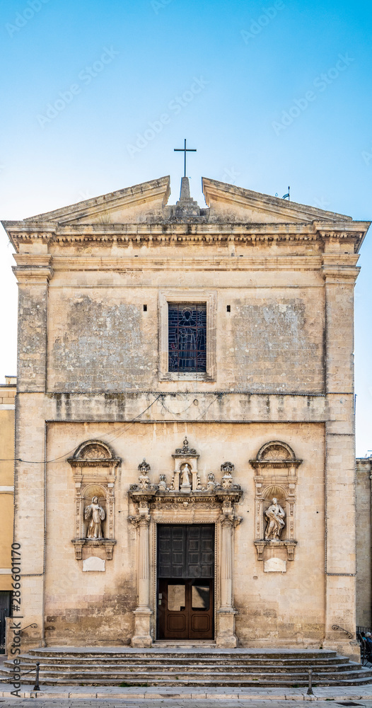 The mother church of Cavallino, Lecce, Puglia, Salento, Italy. In baroque style. Wooden portal and niches with statues on the sides, on the facade.