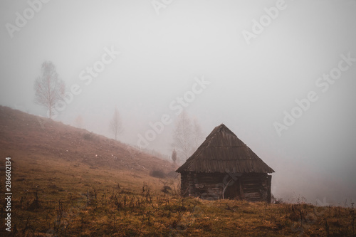 Autumn landscape with traditional houses in Fundatura Ponorului, also known as "The palm of God", Sureanu Mountains, Romania