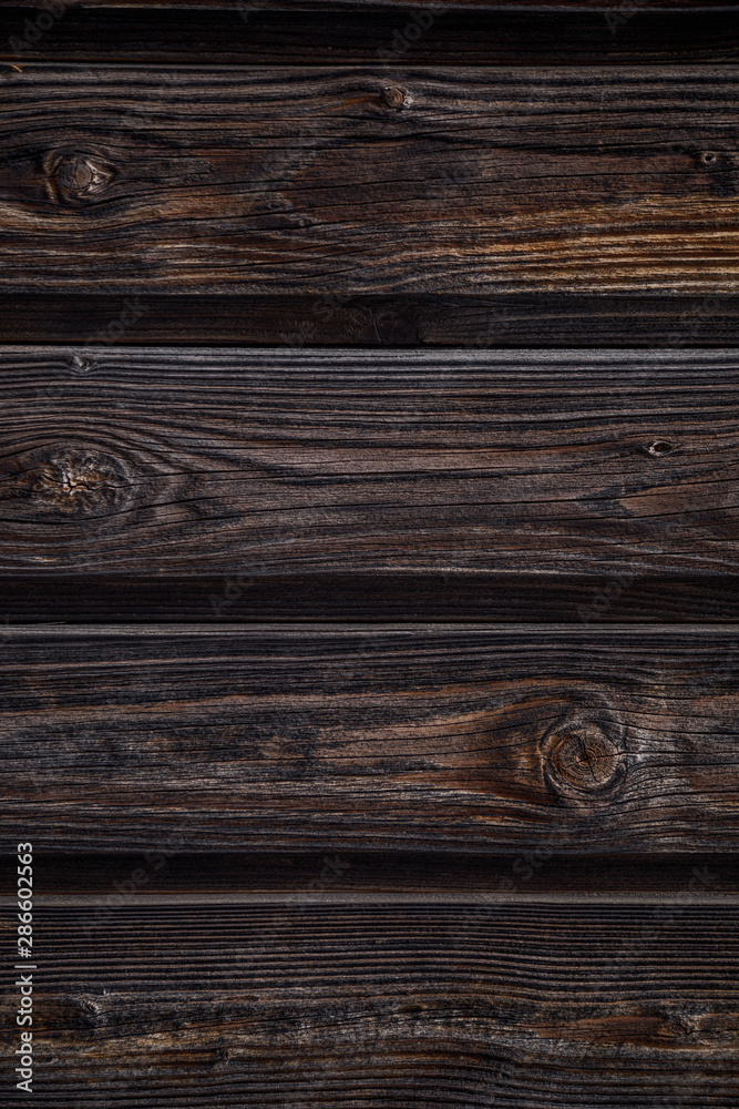 Dark brown wooden background. Four horizontal boards with knots. Natural wood texture. Vertical layout Dark brown wooden background. Four horizontal boards with knots. Natural wood texture. Vertical layout