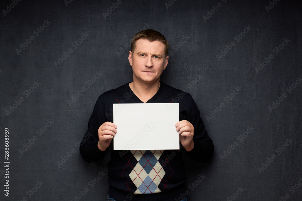 Naklejka premium Portrait of thoughtful man holding white blank paper sheet