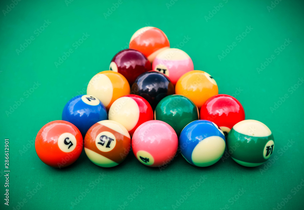 Triangle of colored pool billiard balls on green cloth Triangle of colored pool billiard balls on green cloth
