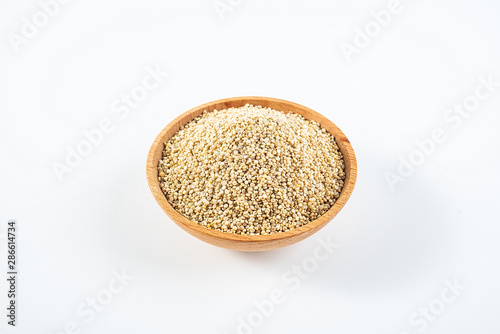 A wooden bowl of miscellaneous grains buckwheat on a white background
