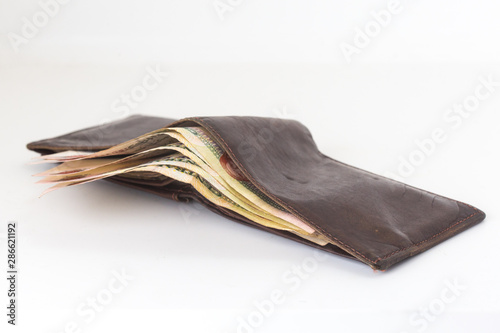 200 Egyptian pound bills in a dark brown wallet isolated on a white background 