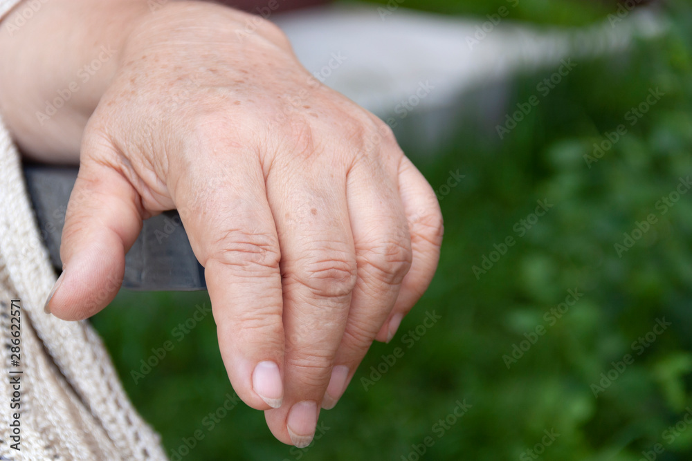 the hand of an elderly woman on the arm of a chair the hand of an elderly woman on the arm of a chair