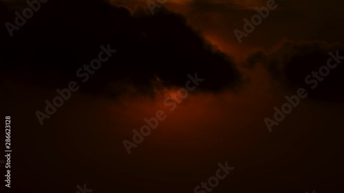 Time lapse of sun rising behind dark cumulos clouds photo