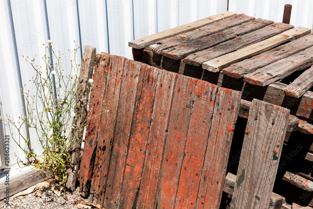 Old broken wooden palettes standing unused.