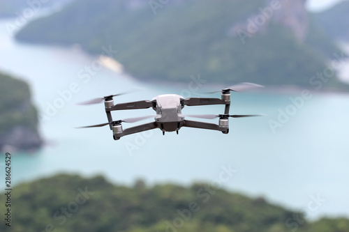 Fototapeta Naklejka Na Ścianę i Meble -  Drones while flying in the sky, Ocean and island backgrounds.